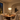 Illuminated Aurelia Gold pendant in a warm Mediterranean dining room