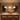 Three illuminated Aurelia Gold pendants above a kitchen island at night