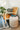 Quinn Ottoman pumpkin orange, styled in a cozy corner as a standalone accent ottoman.